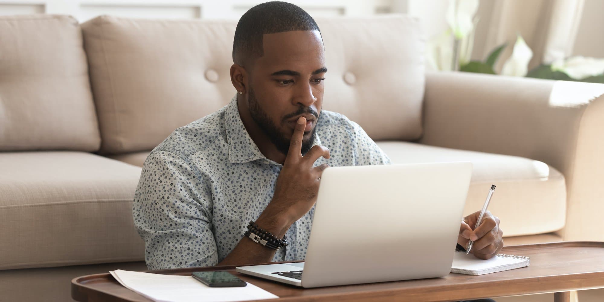 person sitting on floor in front of coffee table with laptop