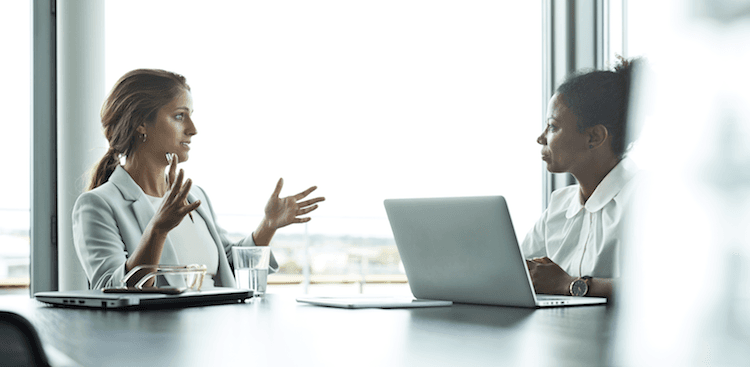 person sitting in a conference room talking with their boss