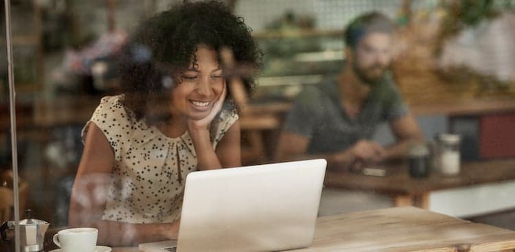 person at coffeeshop sitting with a computer courtesy pixdeluxe/Getty Images